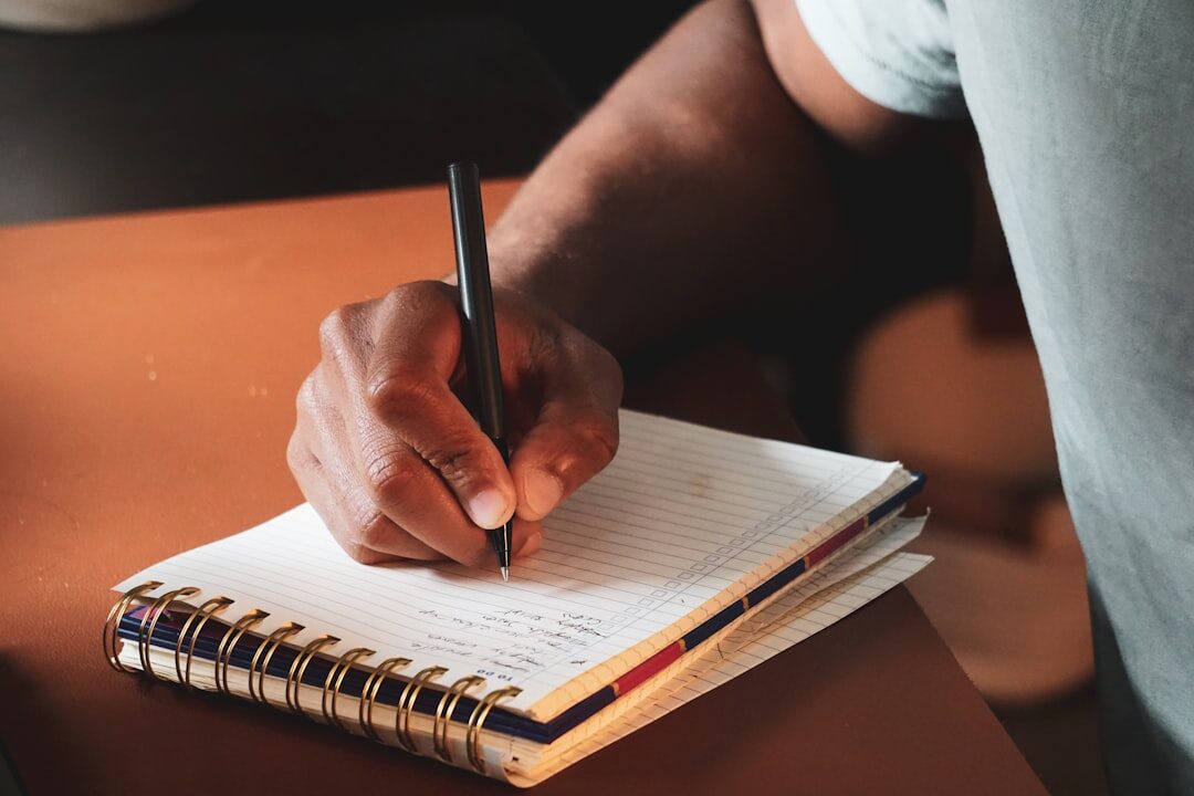 person writing in notebook